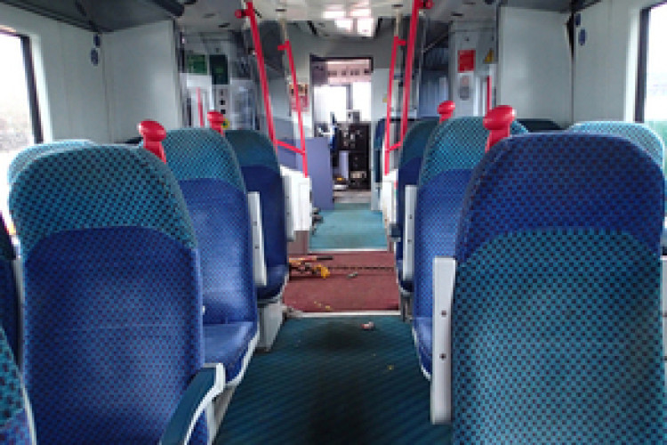 Picture shows the interior of the train, with (if you look closely)  the floor buckled by the excavator bucket beneath it. 