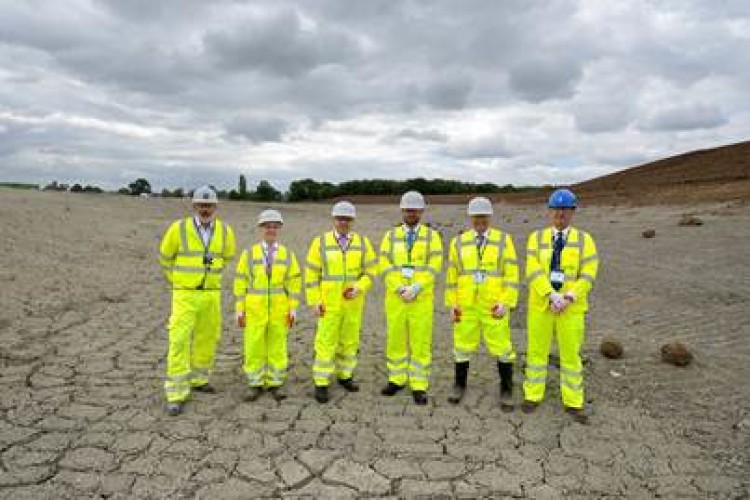On the site of the main rainwater impounding lake are, left to right, Jon Neve of  Turner & Townsend, Gareth Brewerton and Phil Newland of Cambridge Water, Brian Nearney from Cambridge Uni and Tim Orange and Mike Sloan from Cambridge Water