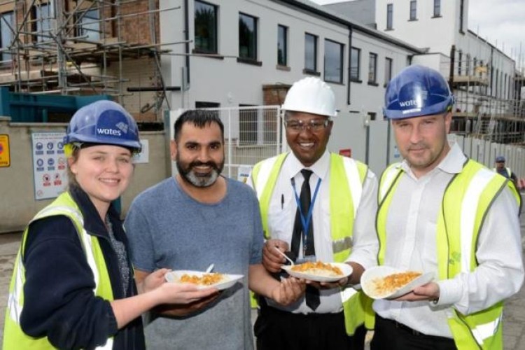 Mohamed Moween (without hard hat) feeds the Wates team
