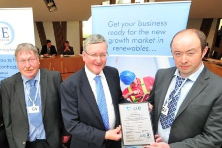 Scottish energy minister Fergus Ewing presents father and son Graham and Jamie Miller of West Coast Electrical with their MCS certificate