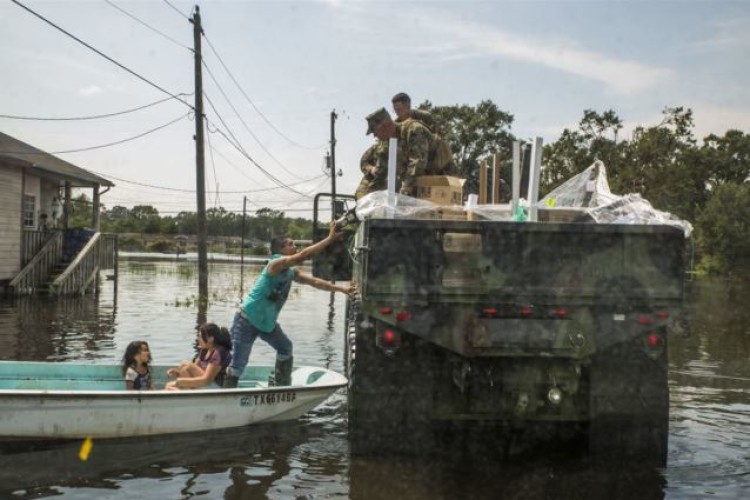 Marines hand supplies to a family in Orange, Texas