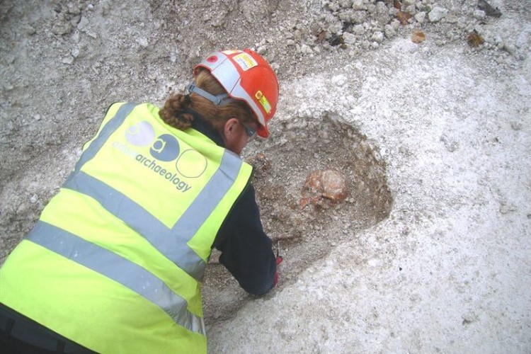 A member of Oxford Archaeology uncovers a burial. (Copyright Oxford Archaeology)