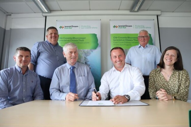 Irish Rail infrastructure programme manager Aidan Bermingham (standing, left) and Jacobs&rsquo; vice president Dom Lynch (seated, second right) pose for a photo with colleagues
