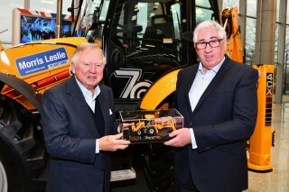 JCB Chairman Anthony Bamford (left) presents Morris Leslie with a special scale model version of the Platinum Edition backhoe loader produced to mark the JCB machine’s 70th birthday