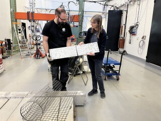 Sebastian Almfeldt and Karin Lundgren test a carbon fibre reinforced concrete slab in the structures lab at Chalmers University of Technology. In the foreground is a textile reinforcement mesh made of carbon fibre [Photo: Chalmers | Mia Halleröd Palmgren]