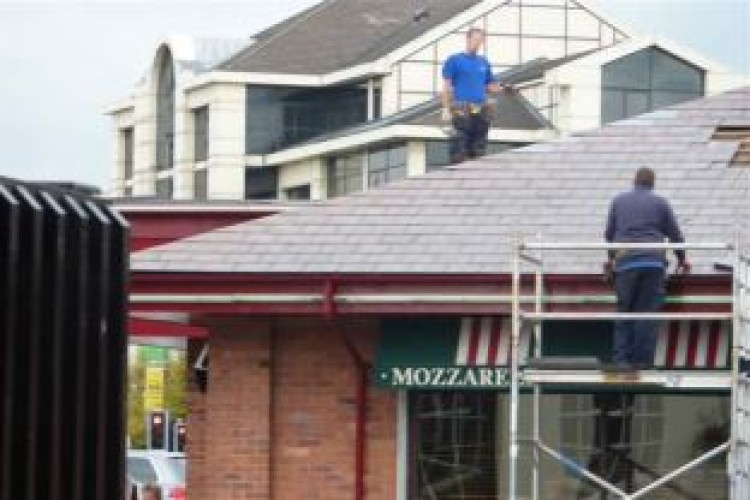 Workers were spotted replacing broken tiles without proper safety equipment