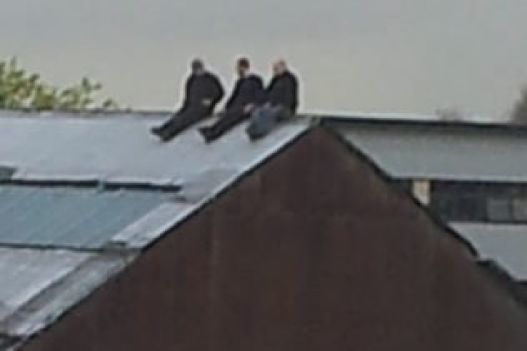 Three men were spotted on the roof of a furniture warehouse in Trafford Park without any safety precautions in place