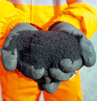 Waste rubber is reduced to a finely-milled crumb which can be added to the asphalt mix