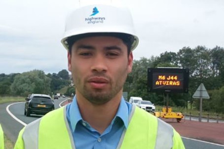 Highways England project manager Jobert Fermilan in front of a sign announcing in Lithuanian that junction 44 of the M6 is open to traffic
