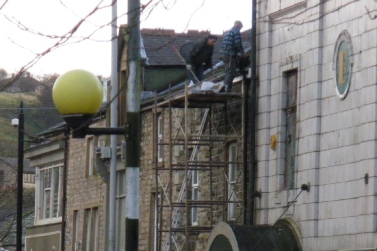 Jack Sanderson (right) and another worker at the top of a dangerous scaffolding tower in Bacup