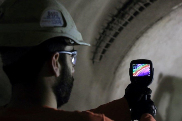 Engineer Francisco Gallego uses a thermal imaging camera to monitor a section of sprayed concrete lining at Bond Street Station