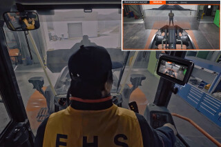 While the bucket hides a pedestrian from view, they can be seen on the monitor in the cab