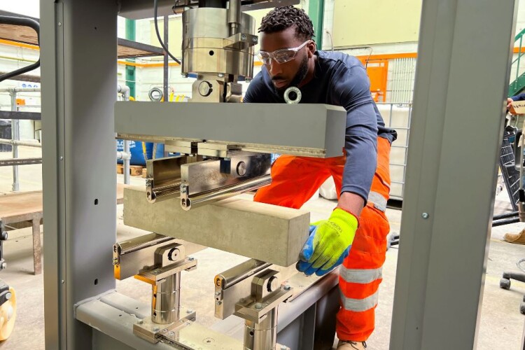 Concrete technician Abayomi Adebari tests a beam in the materials lab