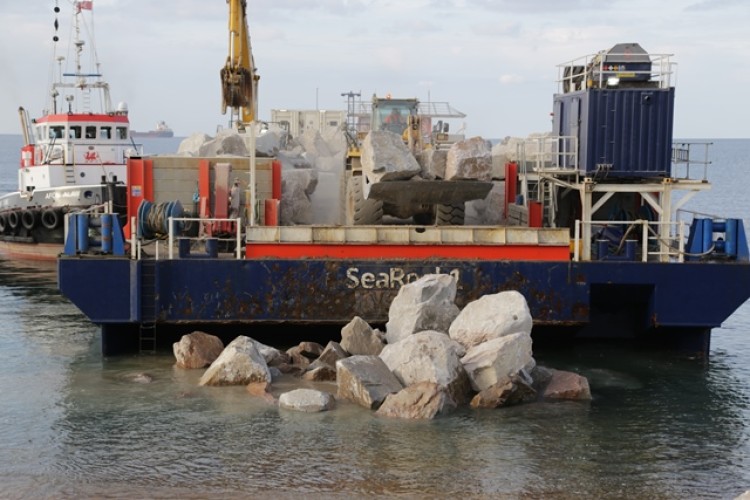 The Mobile Pearl dropped anchor offshore and the rocks were barged ashore according to tides