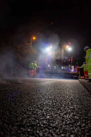 A paving machine lays asphalt containing hydrated lime on the A38 in Devon