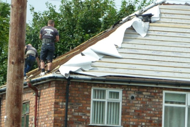 Phillip McGinn (right) and another worker on the roof of a house in Maghull