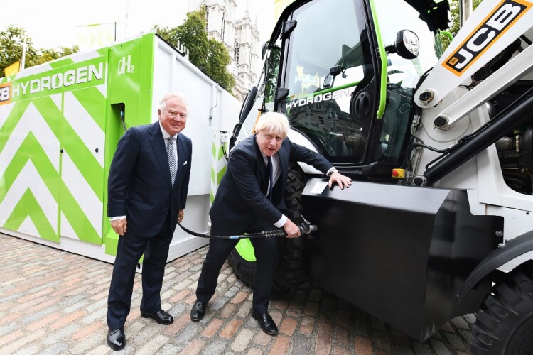 The prime minister pretends to fill the tank of JCB's prototype hydrogen-powered backhoe loader