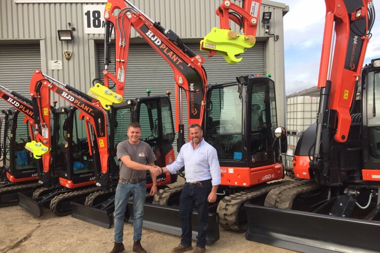 Harry Denton, left, takes delivery of his new Kubota machines