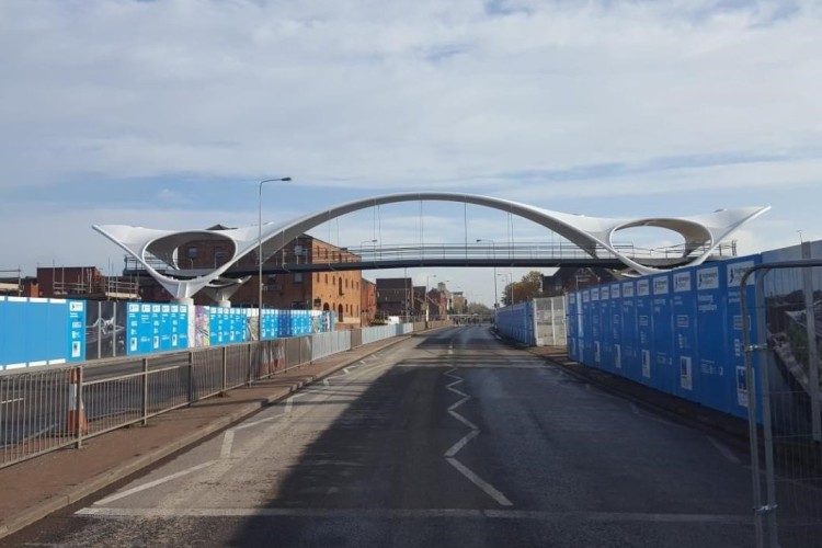 The bridge is covered by a curving steel canopy with sheltered viewing balconies at each end 