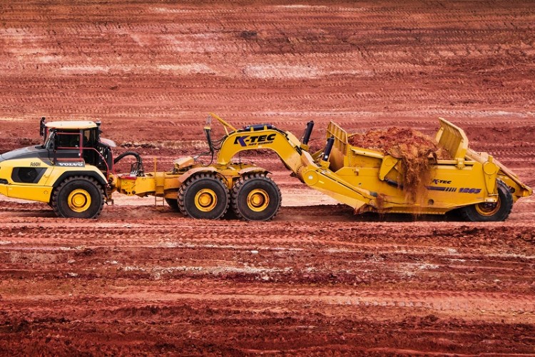 A K-Tex scraper box being pulled by a Volvo articulated dump truck