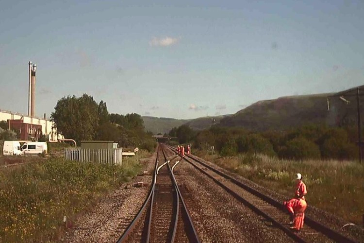 Train camera image looking towards Port Talbot showing workers on the open main line approximately 100 metres apart