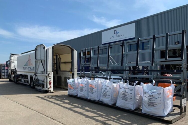 Reused cullet and green electricity contributed to the achievement of zero-carbon flat glass. Two bags of this cullet being collected from JCL Glass weighs 1 tonne so that means 900kg of CO2 has not gone into the atmosphere, says Saint-Gobain