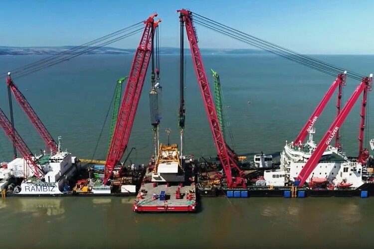 The barge cranes Rambis and Gulliver take the weight of the final head structure