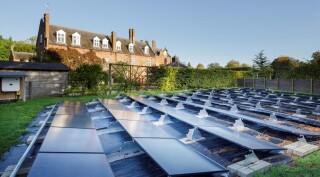 Chippenham Hall, Chippenham, Cambridgeshire. Exterior general view showing solar panels with beech screen and west wing. [Credit: Historic England Archive]