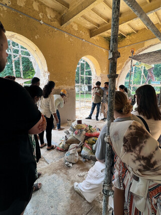 Students watch a practical demonstration of traditional lime plastering