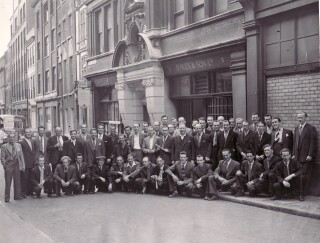 Staff outside the Essex Street office, ready for a works outing in the 1950s