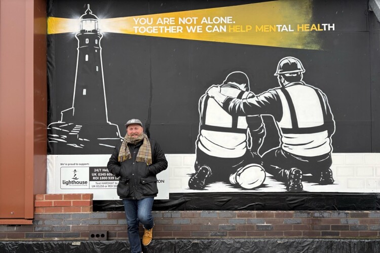 Artists Rob Fenton with his mural in Stoke